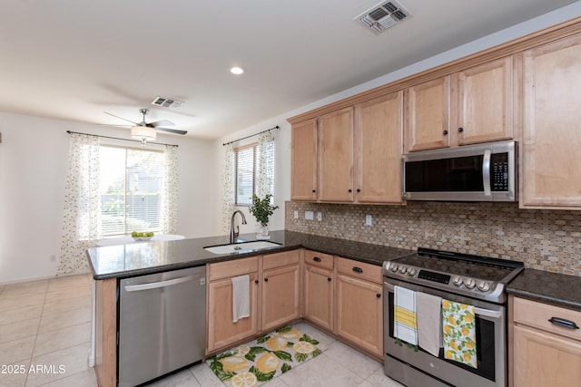 kitchen with tasteful backsplash, sink, stainless steel appliances, and kitchen peninsula