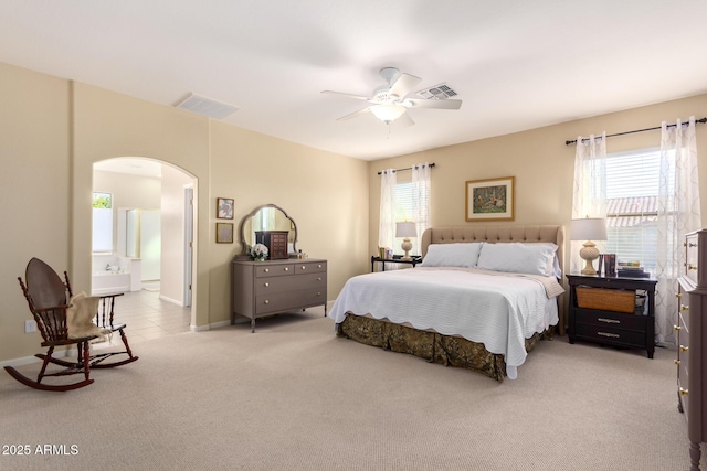 carpeted bedroom with ceiling fan and ensuite bath