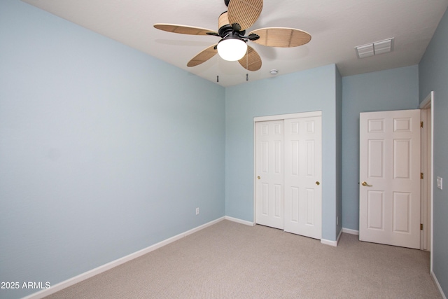 unfurnished bedroom with ceiling fan, a closet, and light carpet