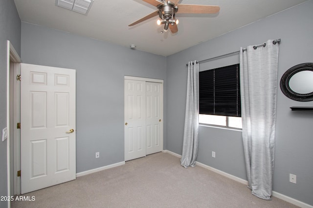 unfurnished bedroom featuring light carpet, a closet, and ceiling fan