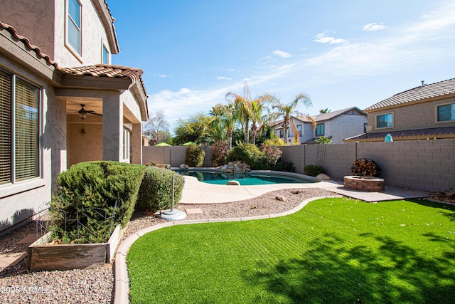 view of pool with an outdoor fire pit and a yard