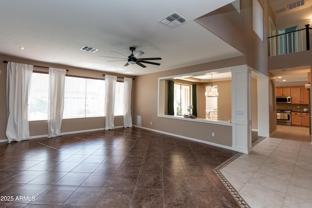 spare room featuring tile patterned flooring, ceiling fan, and ornate columns