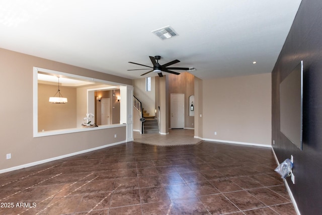 unfurnished living room with ceiling fan with notable chandelier