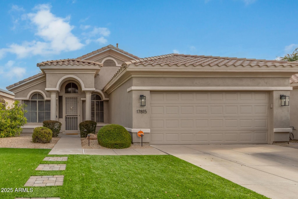 mediterranean / spanish-style home with a garage and a front yard