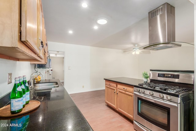 kitchen with ceiling fan, sink, stainless steel range with gas cooktop, extractor fan, and light wood-type flooring