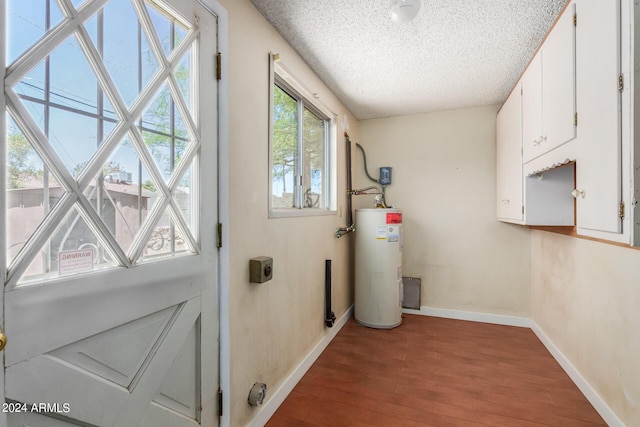 entryway with gas water heater, wood-type flooring, and a textured ceiling