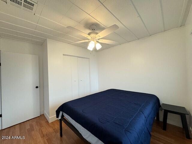 bedroom featuring hardwood / wood-style flooring, a closet, and ceiling fan