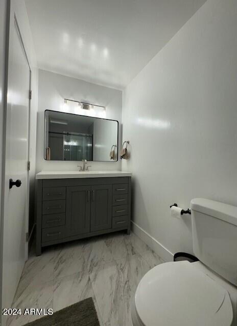 bathroom with vanity, tile floors, and toilet