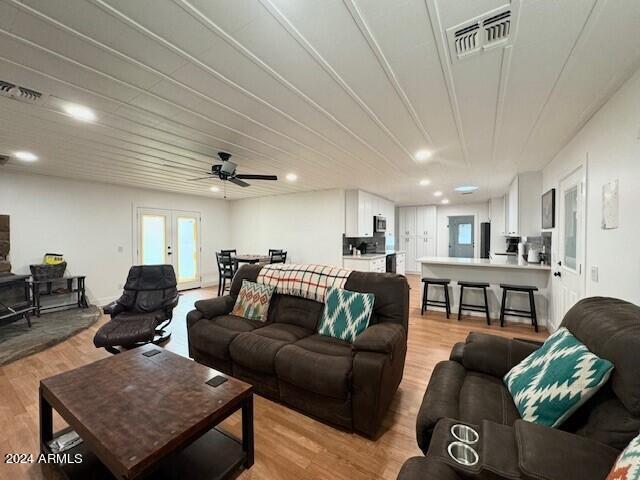 living room featuring french doors, light hardwood / wood-style flooring, and ceiling fan