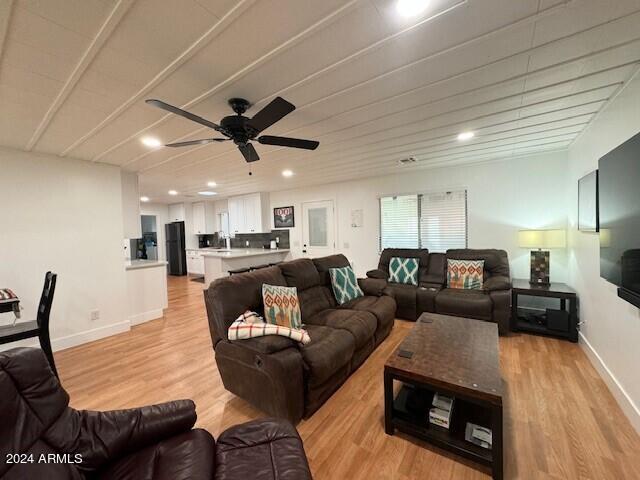 living room featuring sink, light hardwood / wood-style flooring, and ceiling fan