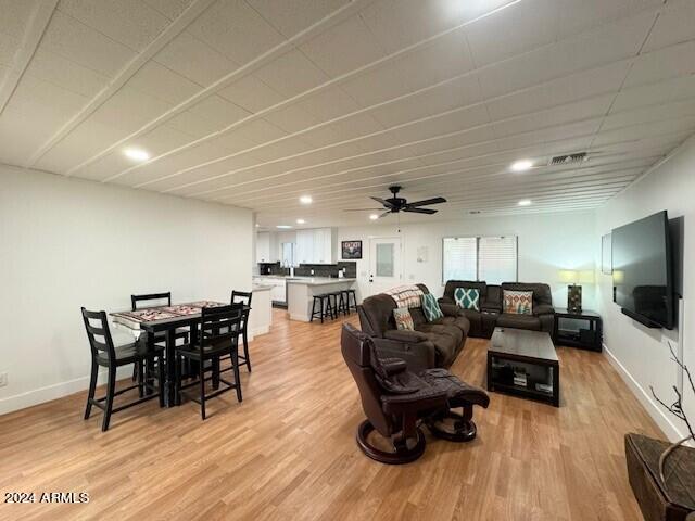 living room with ceiling fan and light wood-type flooring