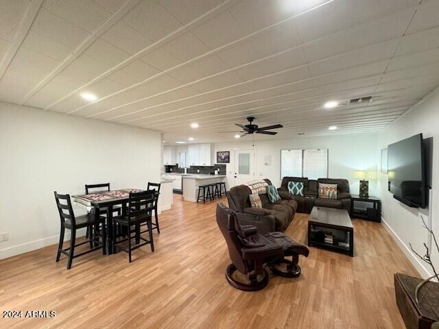 living room with light hardwood / wood-style flooring and ceiling fan