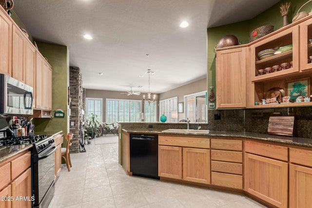 kitchen featuring sink, decorative backsplash, dark stone counters, and black appliances