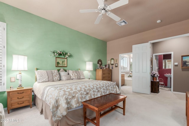 bedroom featuring ceiling fan, ensuite bathroom, and light carpet