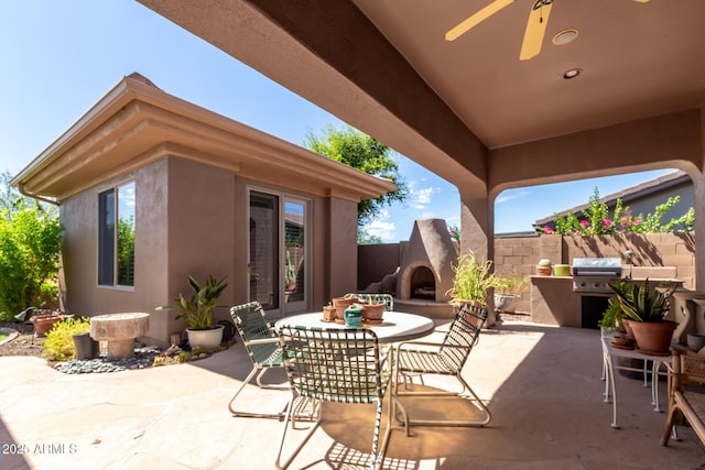 view of patio featuring ceiling fan, an outdoor fireplace, and a grill