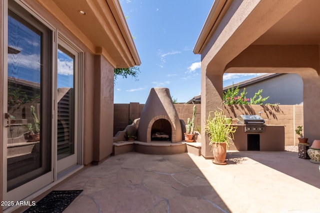 view of patio / terrace featuring area for grilling, exterior fireplace, and exterior kitchen