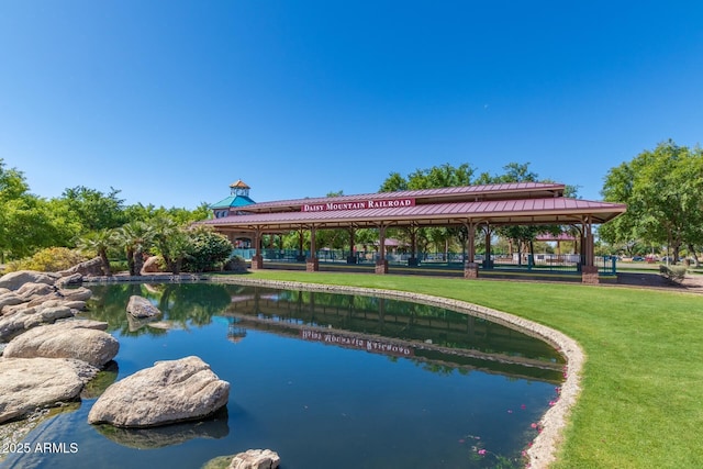 view of swimming pool featuring a water view and a lawn