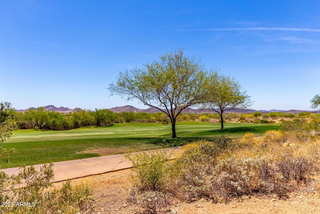 view of community with a lawn, a mountain view, and view of golf course