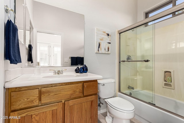 full bathroom with toilet, bath / shower combo with glass door, and vanity