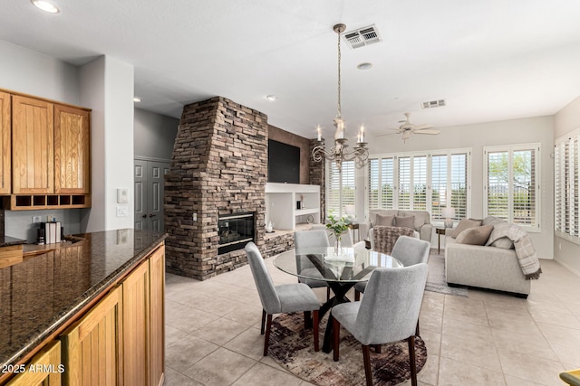 dining area featuring visible vents, light tile patterned floors, and a fireplace