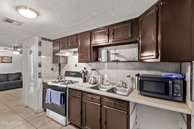 3702 W Sherman St, Phoenix, AZ 85009 - kitchen featuring gas stove, under cabinet range hood, a sink, dark brown cabinetry, and light countertops