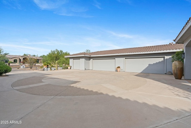 view of front of house with a garage, a tile roof, and stucco siding