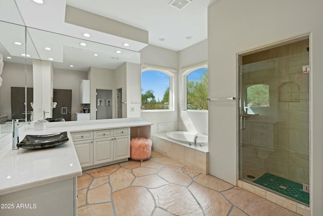 bathroom featuring vanity and independent shower and bath