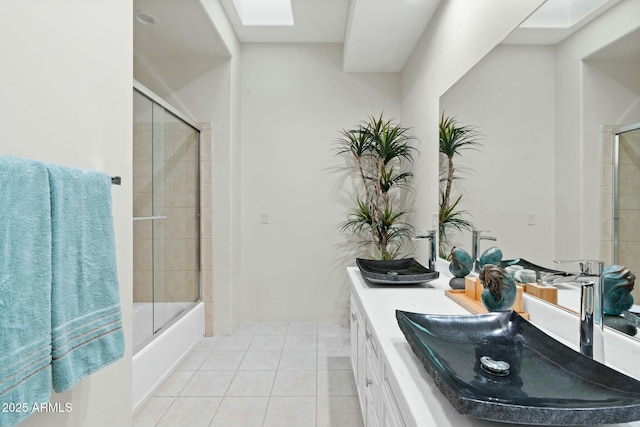 bathroom with vanity, shower / bath combination with glass door, a skylight, and tile patterned flooring