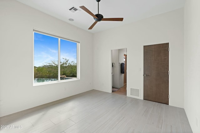 unfurnished room with ceiling fan and a water view