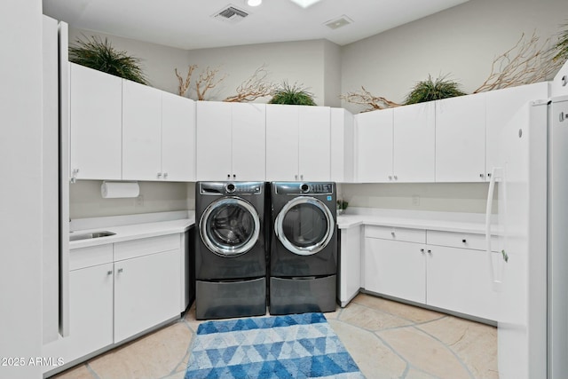 laundry area featuring sink, cabinets, and washing machine and clothes dryer