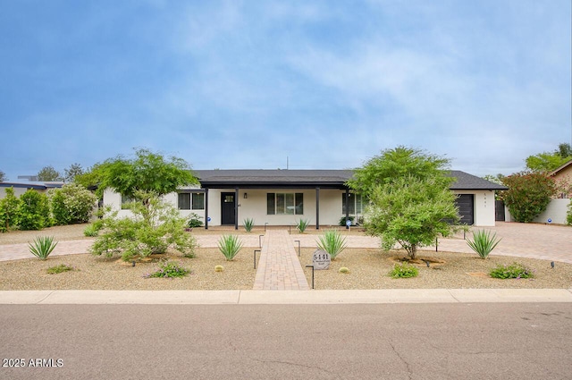 5441 E Wethersfield Rd, Scottsdale, AZ 85254 - ranch-style home featuring decorative driveway, an attached garage, a porch, and stucco siding