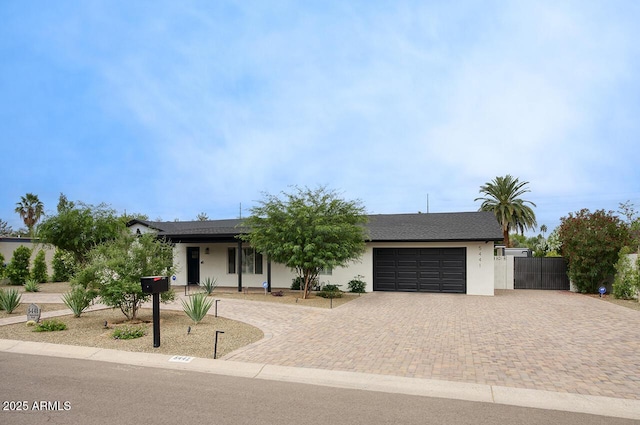 5441 E Wethersfield Rd, Scottsdale, AZ 85254 - view of front of property featuring decorative driveway, a garage, stucco siding, and fence