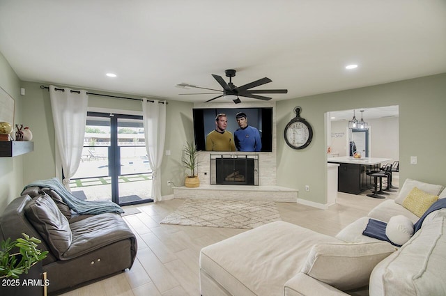 5441 E Wethersfield Rd, Scottsdale, AZ 85254 - living area with a ceiling fan, recessed lighting, a fireplace with raised hearth, light wood-style flooring, and baseboards