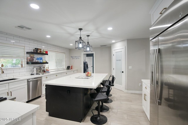 5441 E Wethersfield Rd, Scottsdale, AZ 85254 - kitchen featuring stainless steel appliances, a kitchen island, a sink, white cabinets, and recessed lighting