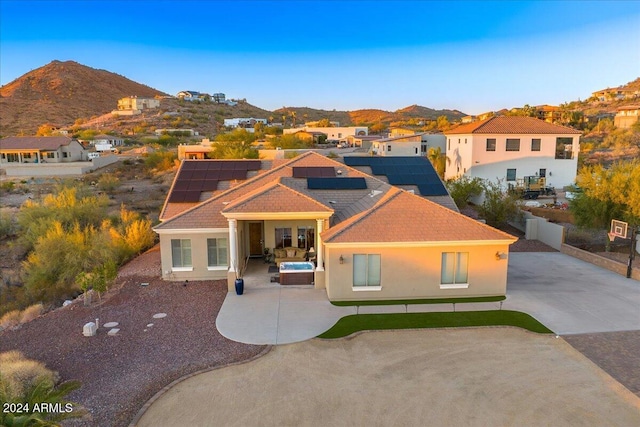 mediterranean / spanish home featuring outdoor lounge area, a mountain view, a patio area, and solar panels