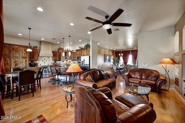 living room featuring ceiling fan and light hardwood / wood-style floors