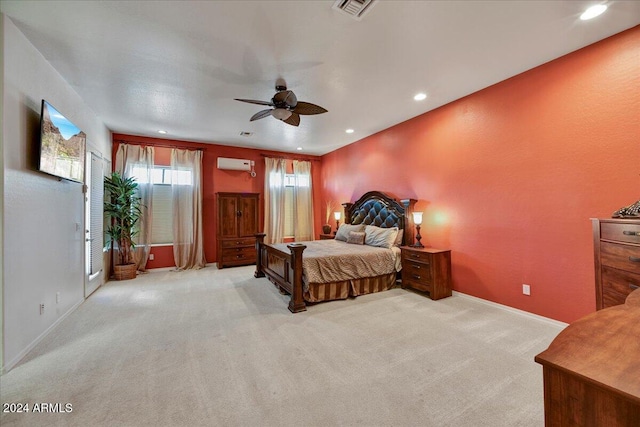 carpeted bedroom with a wall mounted AC and ceiling fan