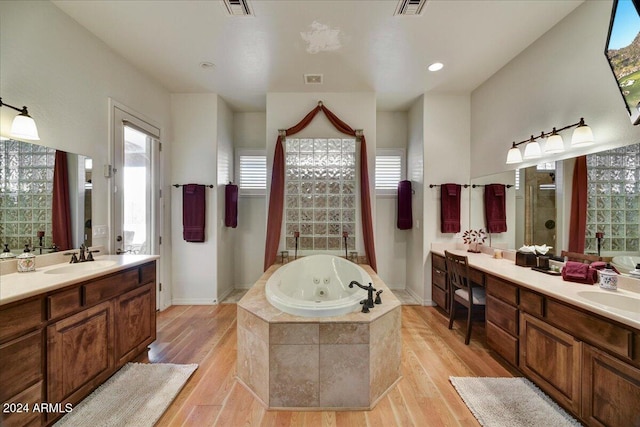 bathroom featuring hardwood / wood-style floors, plenty of natural light, shower with separate bathtub, and vanity