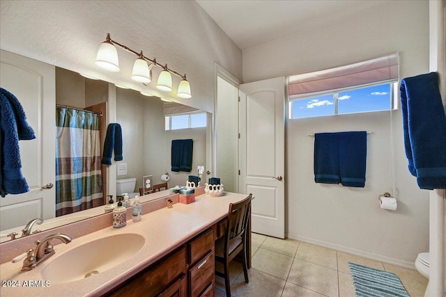 bathroom with tile patterned flooring, toilet, and a healthy amount of sunlight