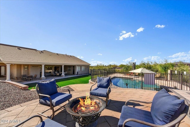 view of patio / terrace with a fenced in pool and a fire pit