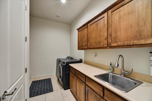 laundry room with cabinets, light tile patterned floors, sink, and separate washer and dryer