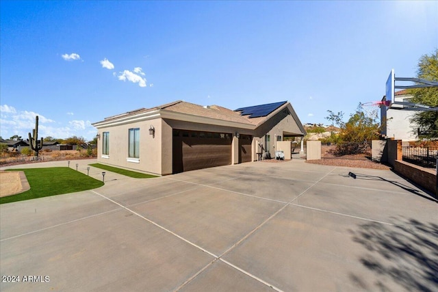 view of property exterior featuring solar panels and a garage