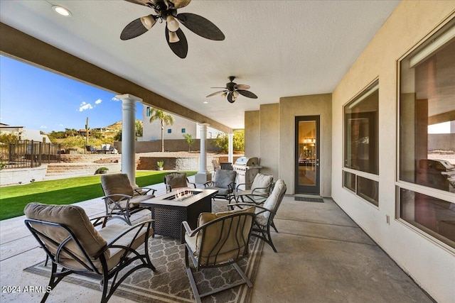 view of patio / terrace with area for grilling, ceiling fan, and an outdoor living space with a fire pit