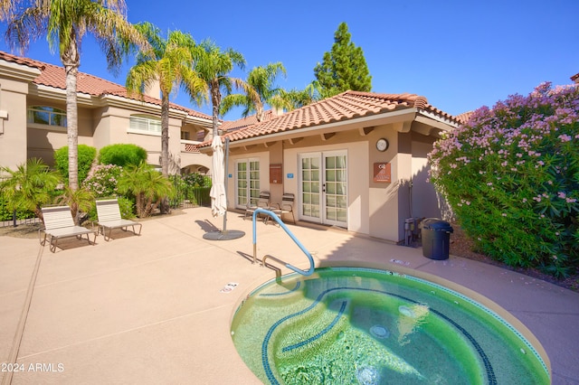 view of pool featuring a patio area, french doors, and an in ground hot tub