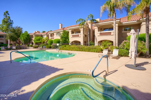 view of swimming pool featuring a community hot tub and a patio area