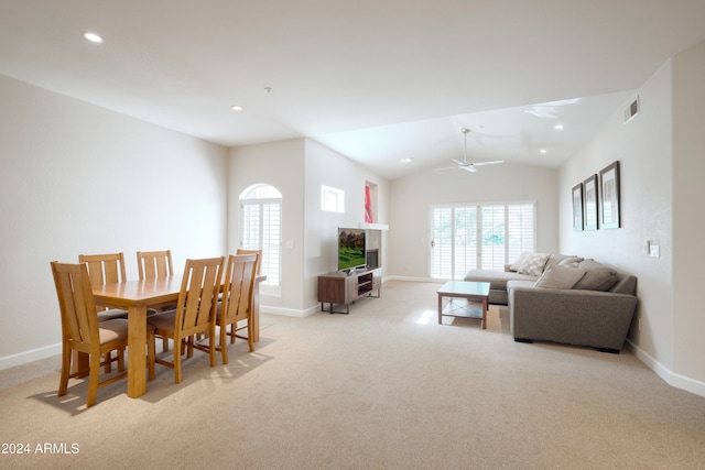 dining area with light carpet, ceiling fan, and vaulted ceiling