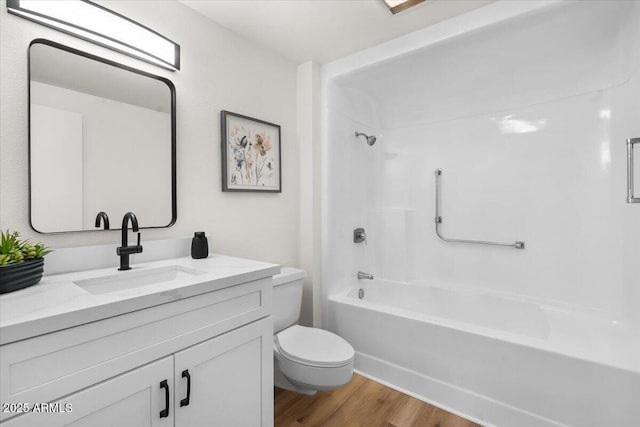 full bathroom with bathing tub / shower combination, vanity, wood-type flooring, and toilet