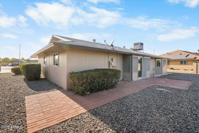 rear view of property featuring a patio and cooling unit