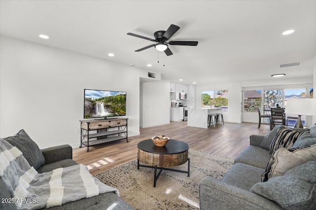 living room featuring hardwood / wood-style floors and ceiling fan