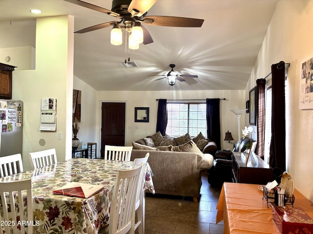 tiled dining area with ceiling fan and lofted ceiling